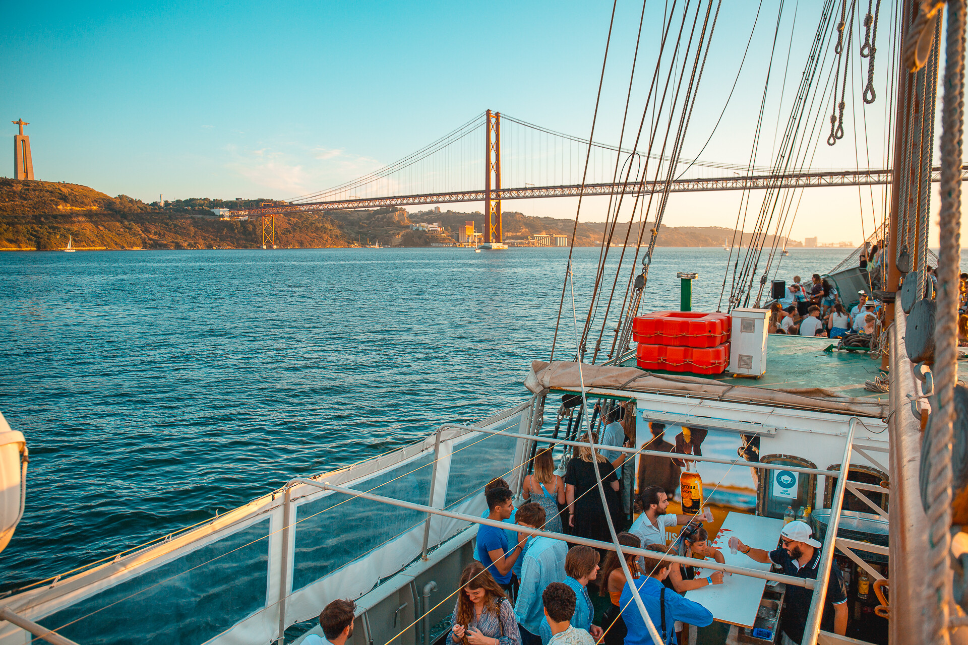 A vibrant scene on a boat shows people socializing and enjoying the sunny weather.